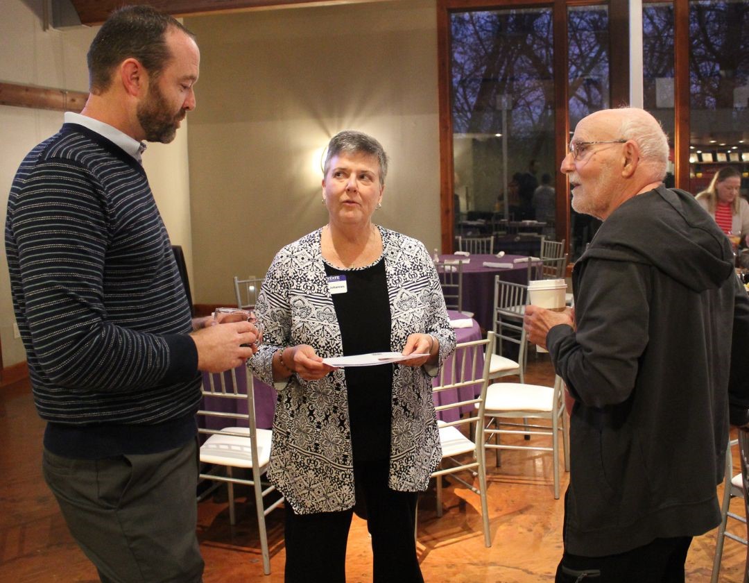 marlin speaking with others at the annual breakfast event