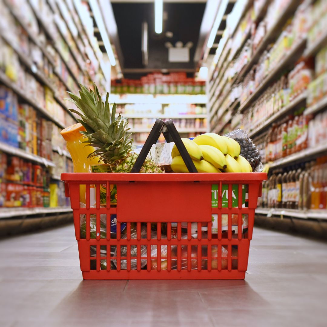 grocery basket in the middle of a grocery aisle on the floor