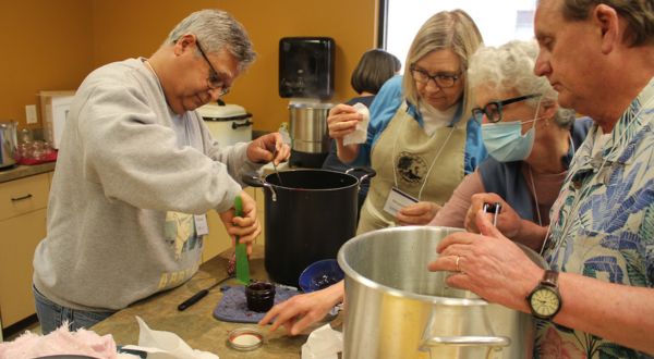 Various master food volunteers adding things to stock pots. 