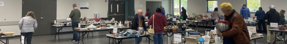 Douglas County Fairgrounds Flory Building set up for the Kitchen Sale with shoppers in side. Several tables with lightly used kitchen items for sale as part of the Extension Master Food Volunteer program funding.