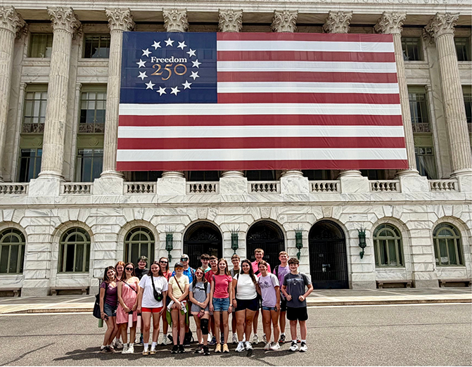 cwf group standing in front of freedom 250 american flag